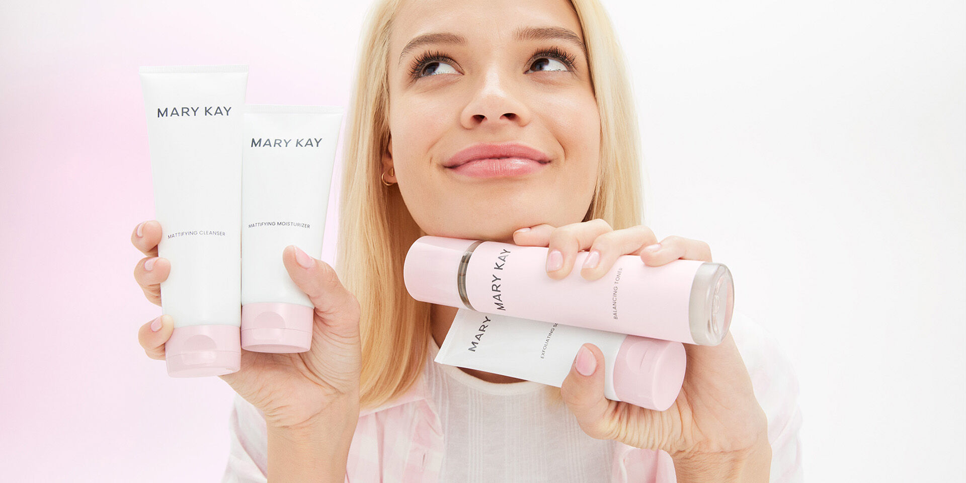 Blonde model holding all 4 products in the Mary Kay Skin Care line