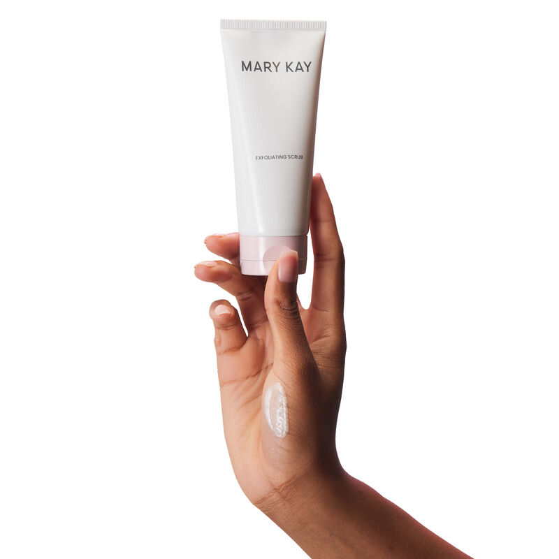 Hand holding tube of Mary Kay Exfoliating Scrub with product rub on the hand