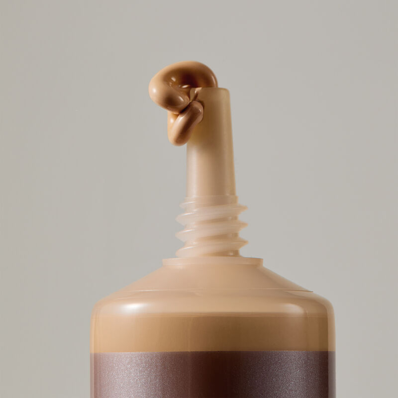 Macro view of TimeWise Matte 3D Foundation needle-nose applicator dispensing Medium 7 shade