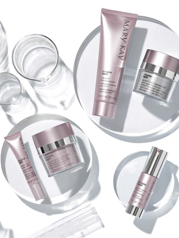 The Mary Kay TimeWise Repair Volu-Firm Set placed on clear platforms with clear scientific accessories.