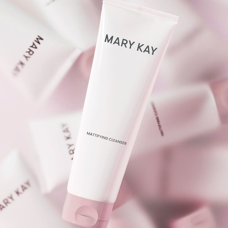 Tube of Mary Kay Mattifying Cleanser in the forefront with multiple bottles of the same in blurry kaleidoscope effect