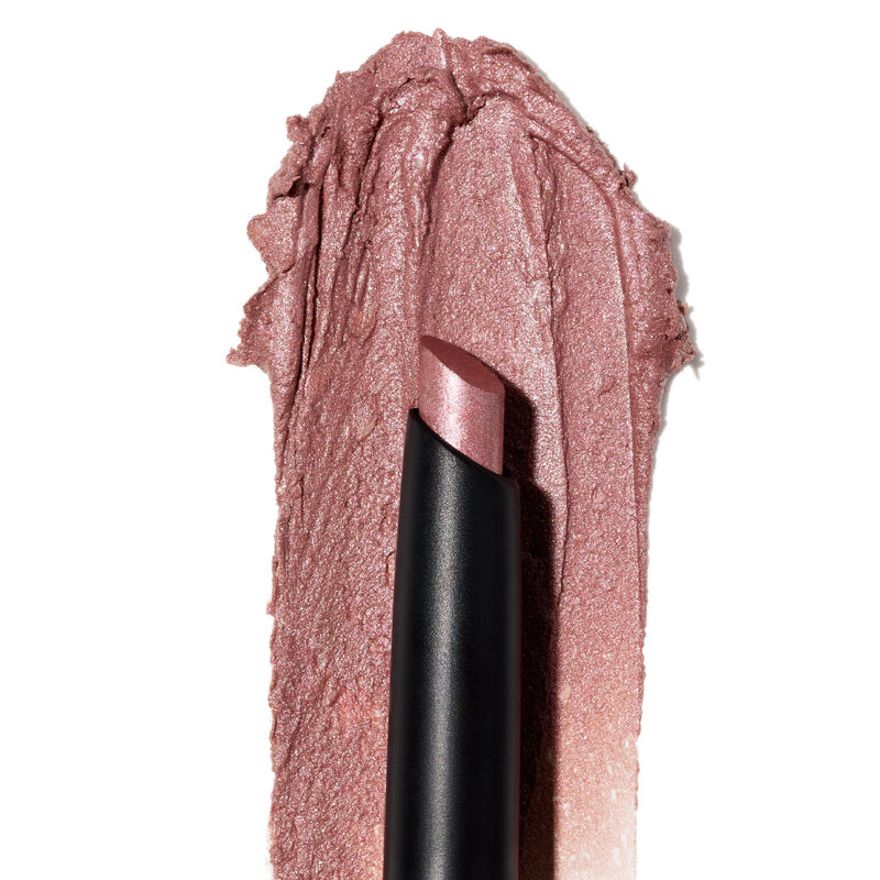 A product rub showing off the Pink Prisms shade, finish and texture appears on a white surface with the uncapped product in front of it.&nbsp;