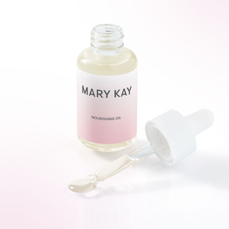 Open bottle of Mary Kay Nourishing Oil standing next to dropper with small pool of oil at its opening.