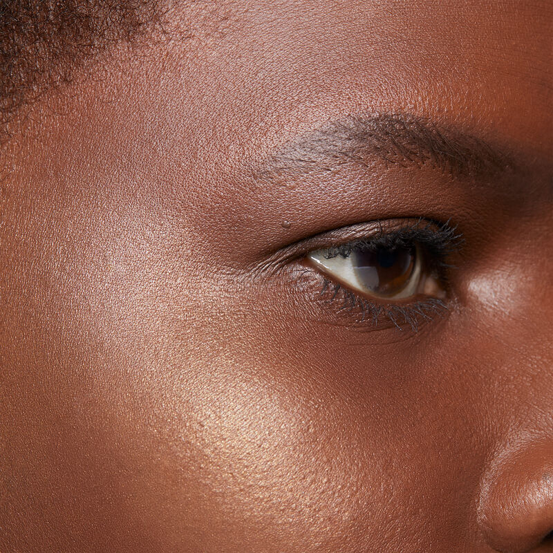Close up of deep-skinned model with black hair and brown eyes wearing limited-edition Mary Kay Illuminating Bronzer image number null