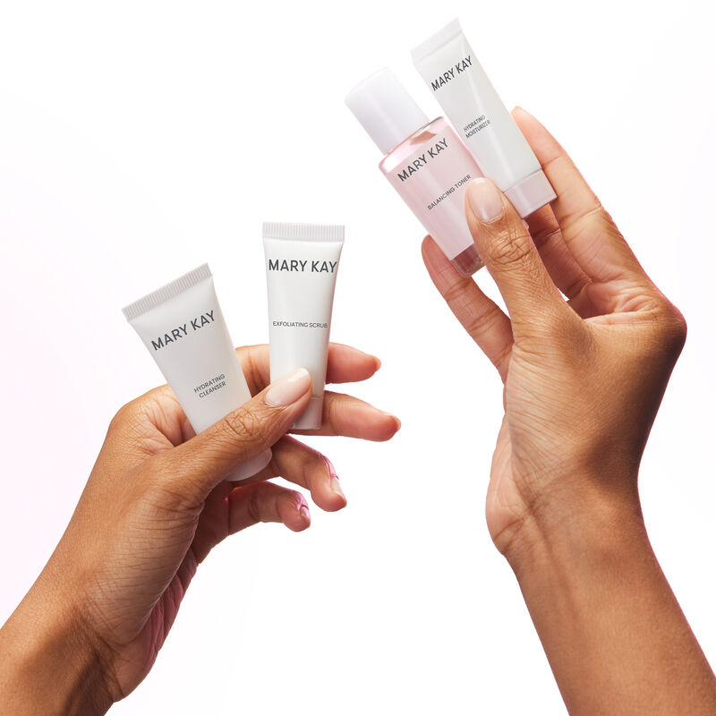 Pair of hands holding all four products in the Mary Kay Skin Care Hydrating Go Set image number null