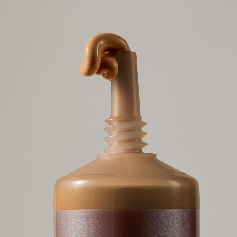 Macro view of TimeWise Matte 3D Foundation needle-nose applicator dispensing Medium 12 shade