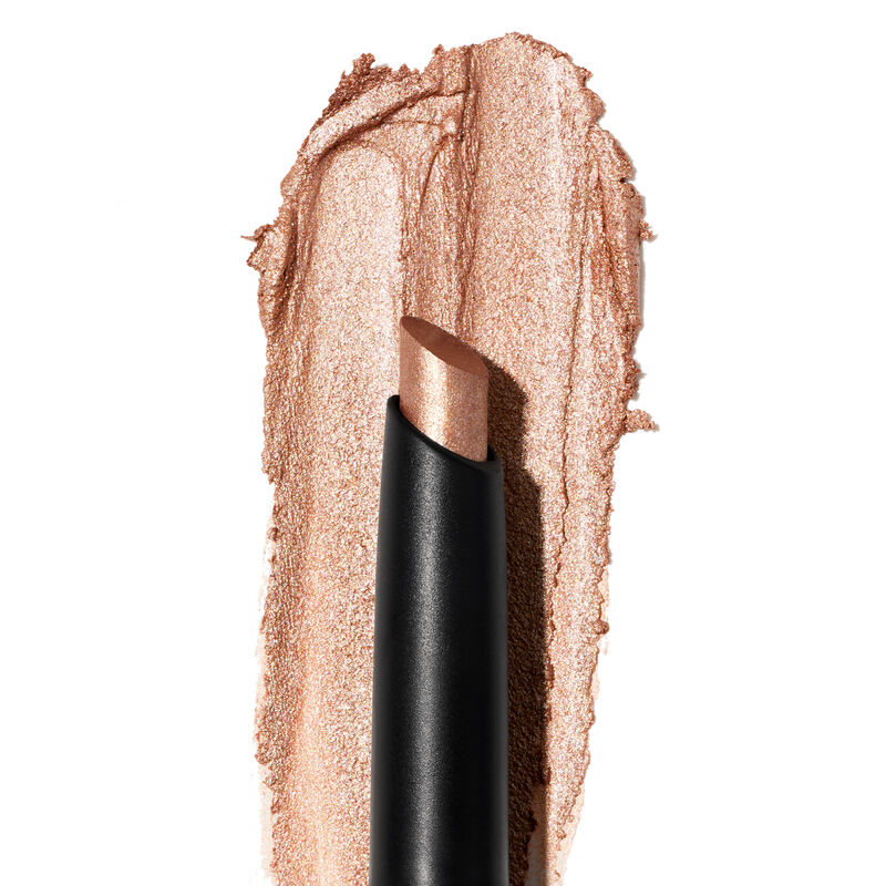 A product rub showing off the Golden Sunrise shade, finish and texture appears on a white surface with the uncapped product in front of it.