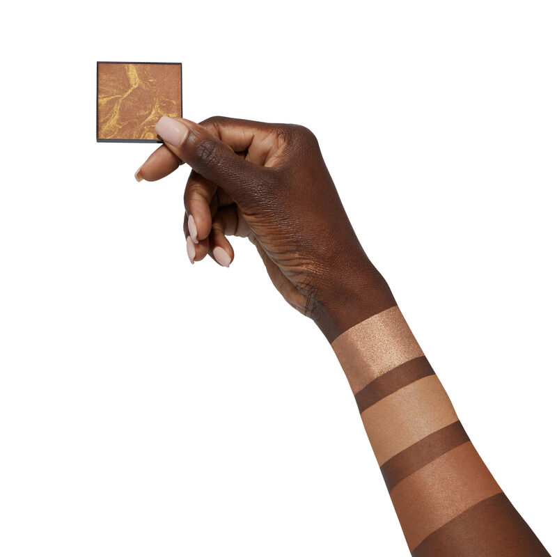 Medium-skinned hand holding limited-edition Mary Kay Illuminating Bronzer image number null