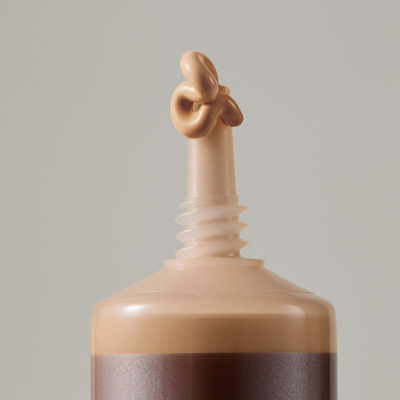 Macro view of TimeWise Matte 3D Foundation needle-nose applicator dispensing Medium 2 shade