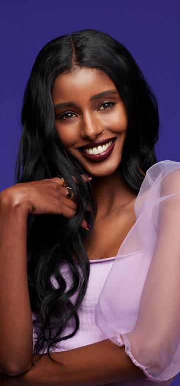 Woman smiling at the camera wearing a deep shade of Mary Kay Supreme Hydrating Lipstick