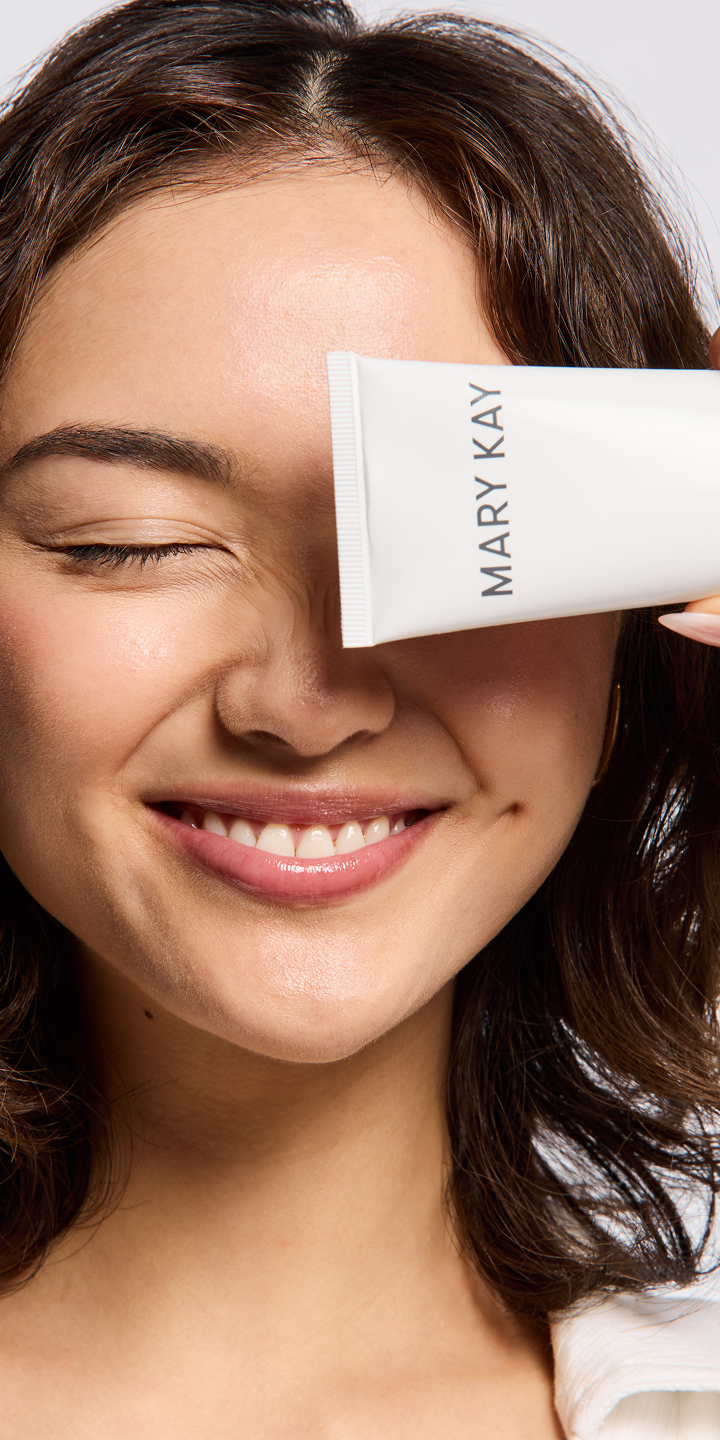 Woman smiling and holding Mary Kay Hydrating Cream Mask