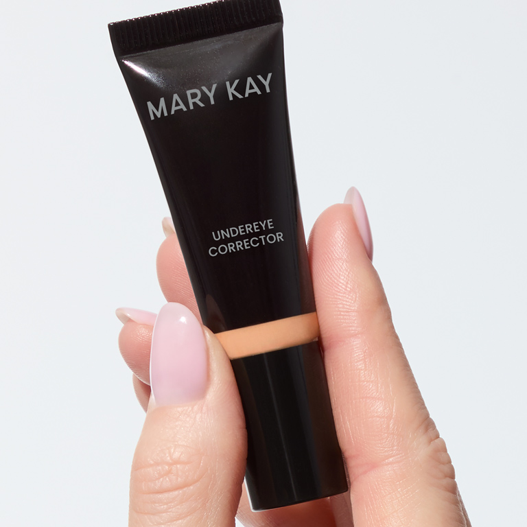 Hand holding both shades of Mary Kay Undereye Corrector