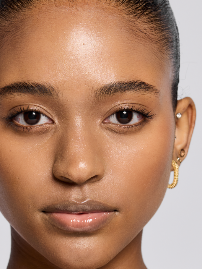 Deep skin tone model shown after applying foundation.