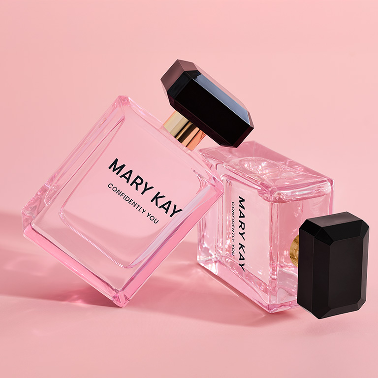 Two Confidently You Eau de Parfum bottles stacked on each other against a pink background